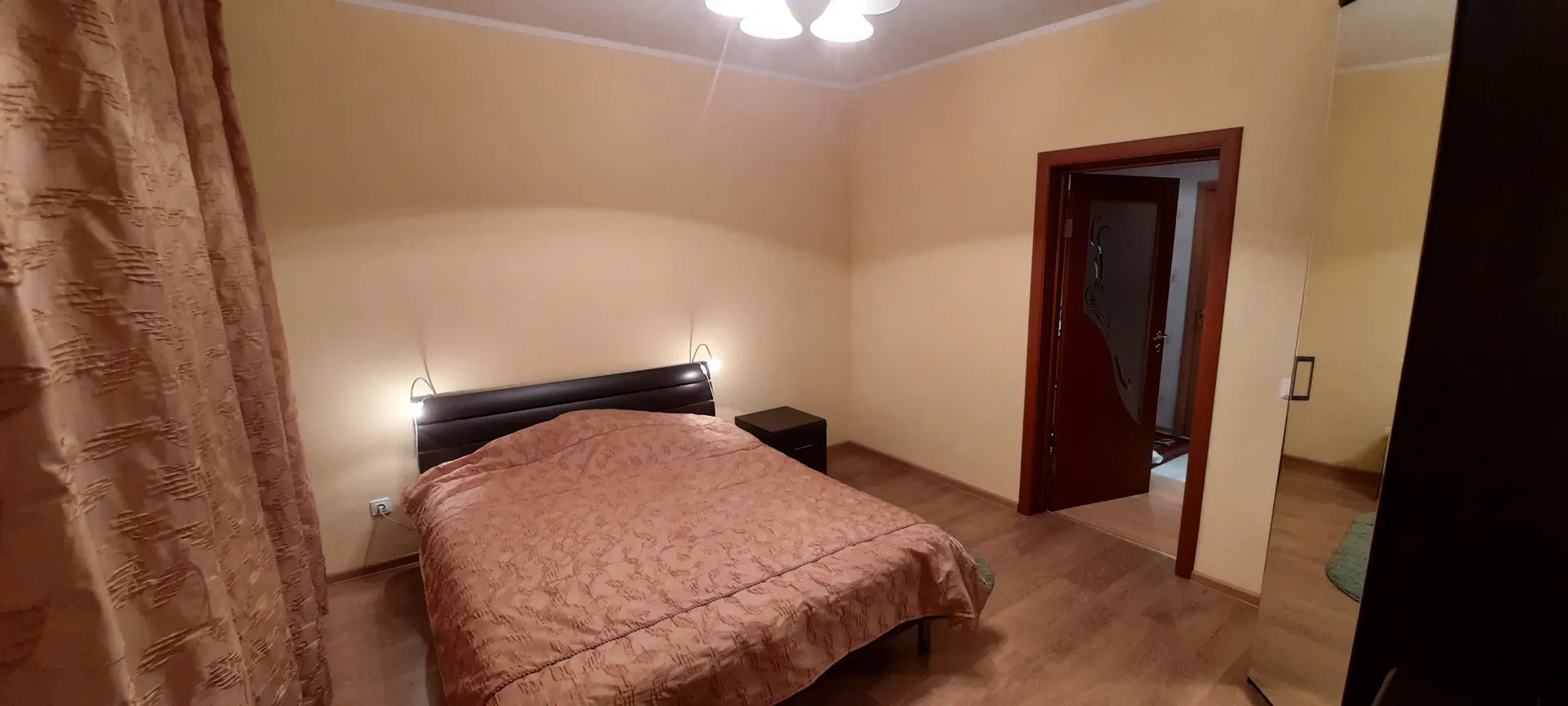 Спальная №2: широкая двуспальная кровать, шкаф, телевизор, комод, тумбочка.