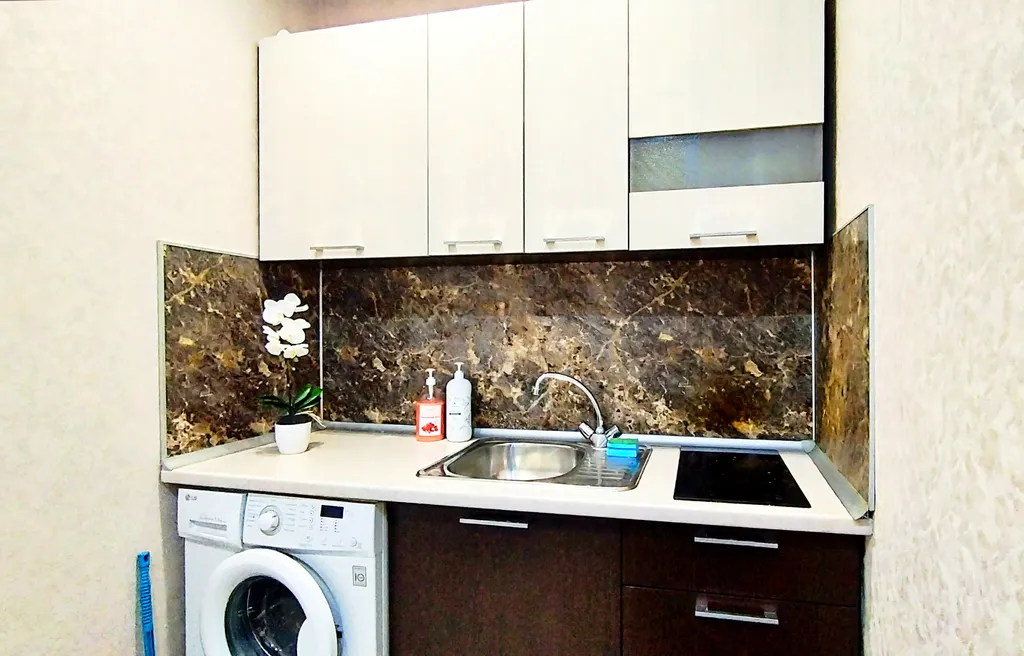 Уютная студия в тёплых тонах с большой угловой ванной для пары