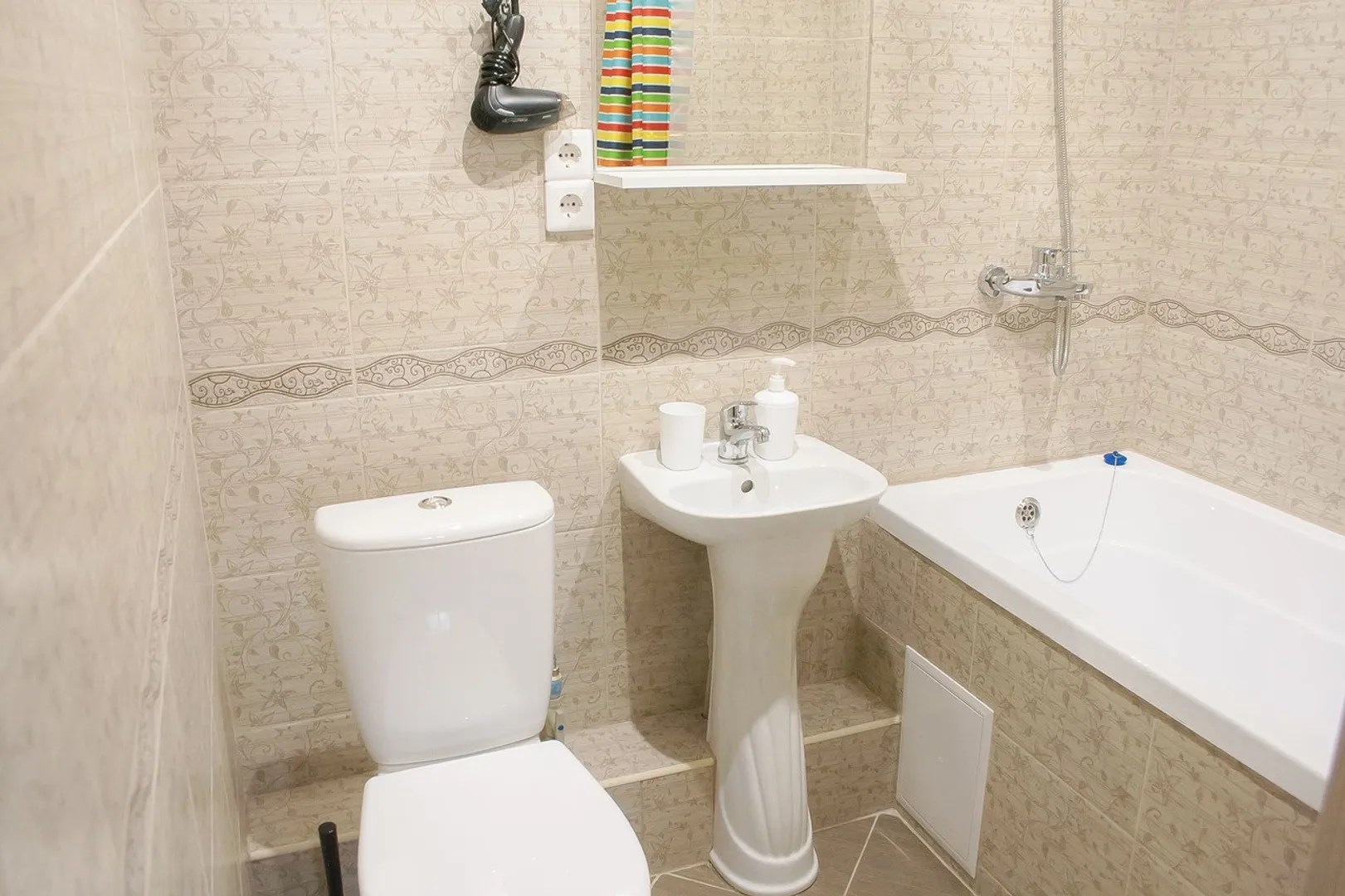 Ванная комната с феном, жидким мылом, гелем для душа и шампунем.