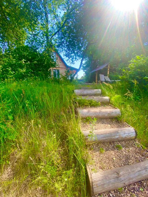 Деревянный дом на берегу реки с беседкой