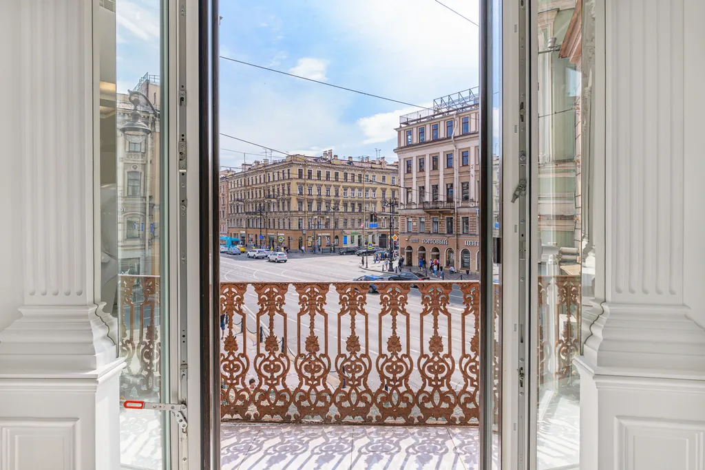 Белые двухъярусные апартаменты с балконом и видом на Невский проспект