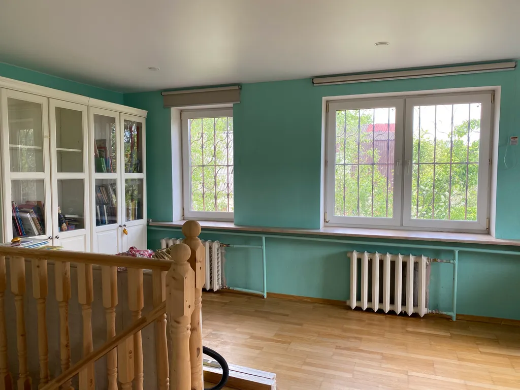 Дом с елкой и снеговиком, за домом манеж с лошадьми