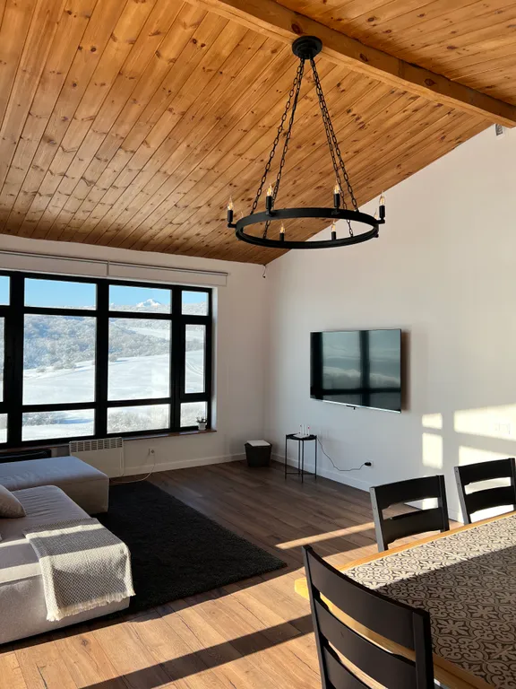 Домик на холме с видом на лес и горы