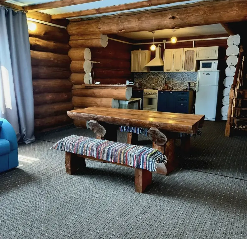 Дом из круглого дерева возле горы