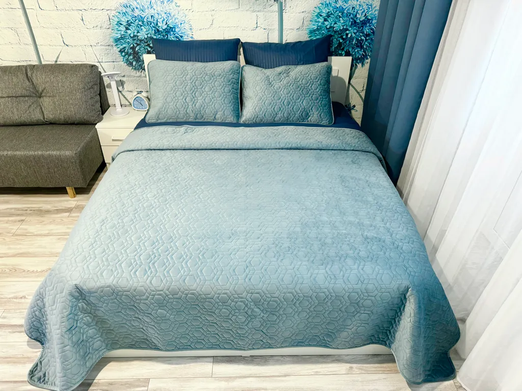 Уютная квартира-студия с большой кроватью и диваном