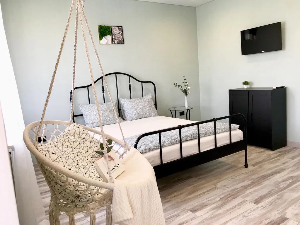 Уютная студия с качелями и видом на тихий зеленый сад