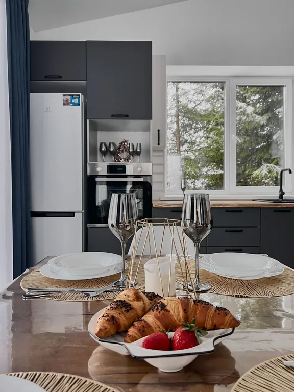 Новый дом в окружении елок с панорамными окнами и баней