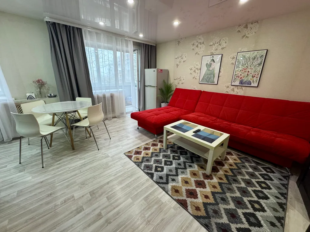 Двухкомнатная студия с красным диваном в центре города