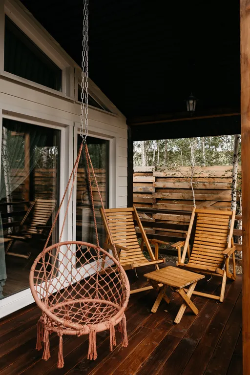 Дом с панорамными окнами и террасой в окружении леса