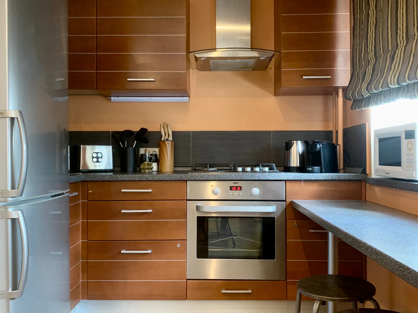 Кухня оборудована полноразмерным холодильником, микроволновкой, газовой варочной панелью и электрической духовкой