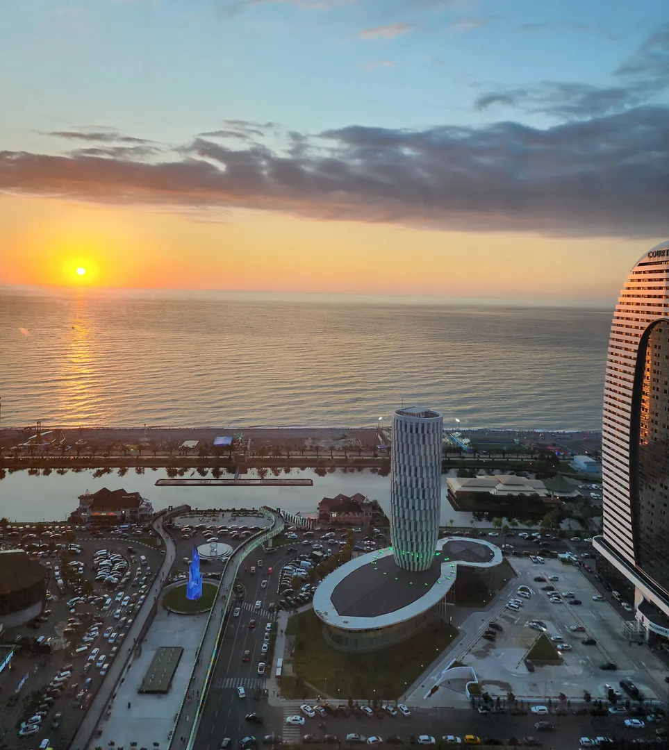 Вид из окна Апартаментов Ramada Plaza Tower Sea View в сторону моря на закате.