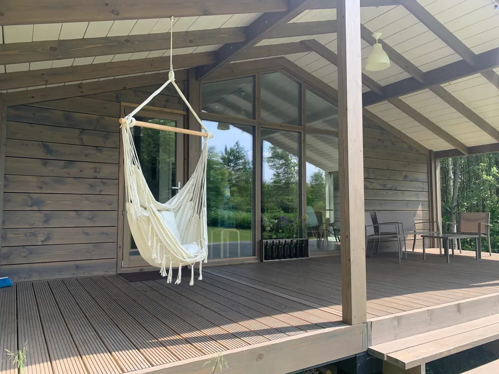 Дом с панорамными окнами в окружении леса