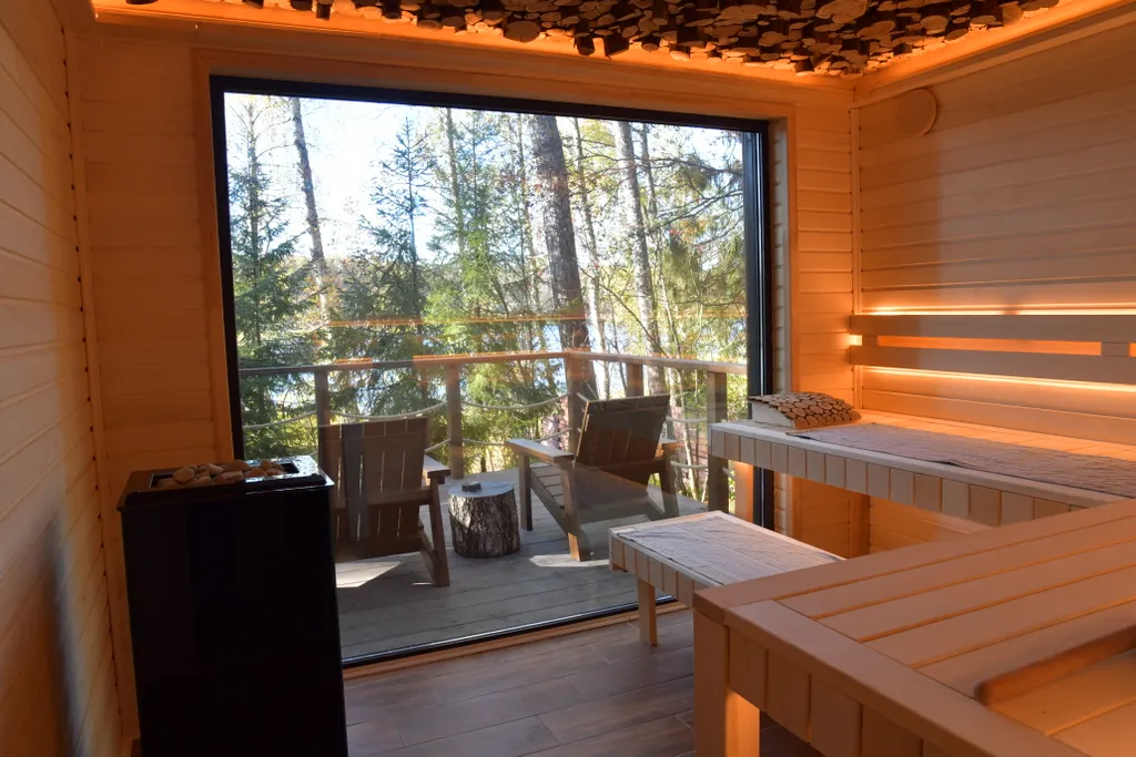 Дом с панорамными окнами в чаще леса у берега реки