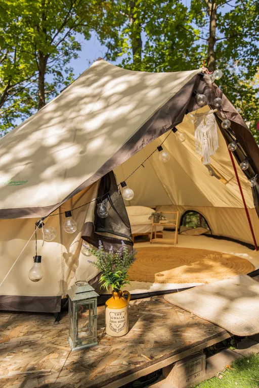 Уютный шатер среди деревьев на берегу озера