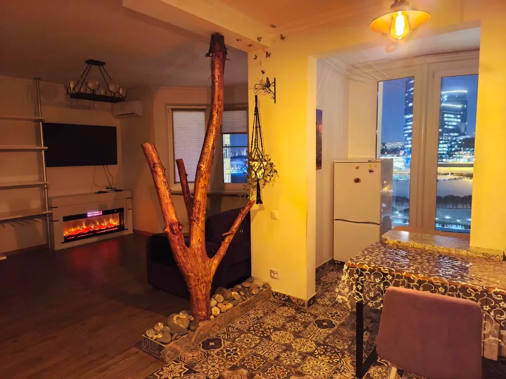 Студия с камином, деревом и видом на реку