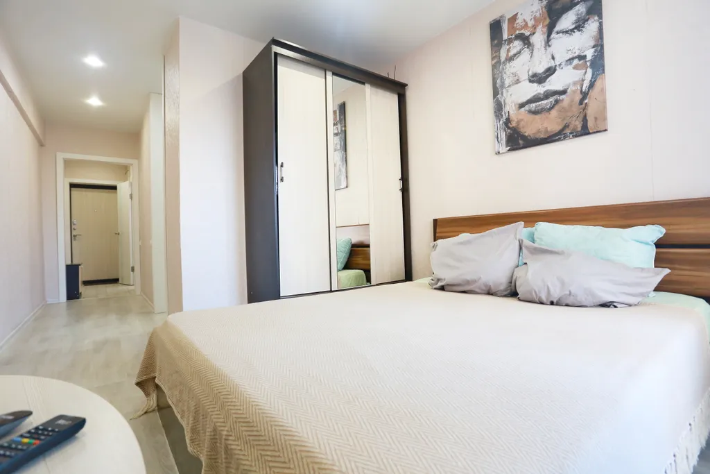 Уютная студия в тёплых тонах с большой угловой ванной для пары