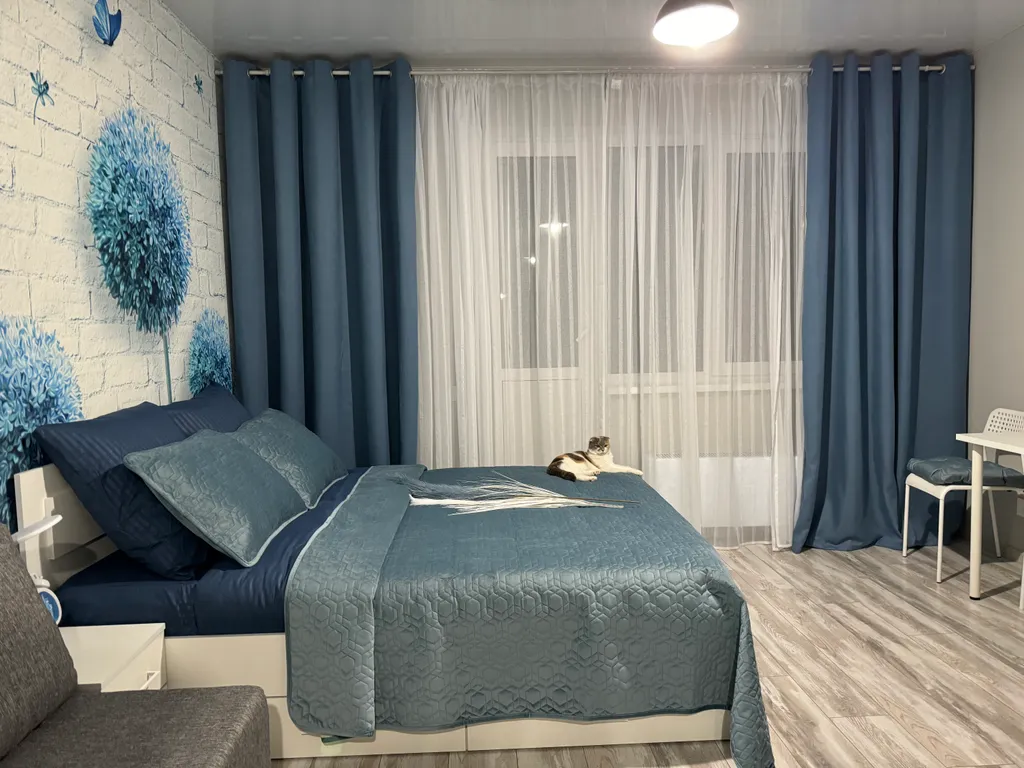 Уютная квартира-студия с большой кроватью и диваном