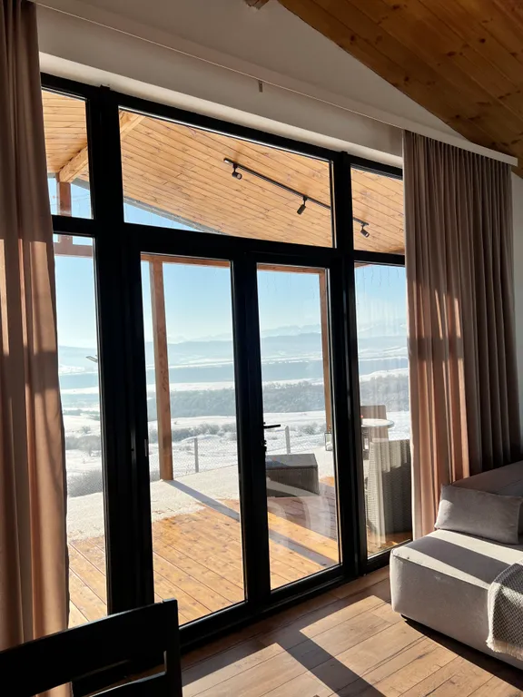 Домик на холме с видом на лес и горы