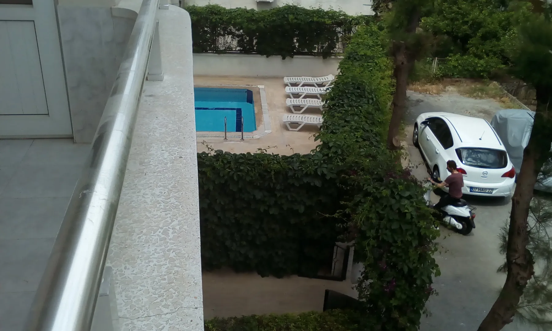 Вид на вход на территорию дома и на бассейн с малого балкона