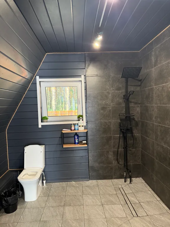 Большой треугольный домик с камином, с ванной у окна с видом на лес