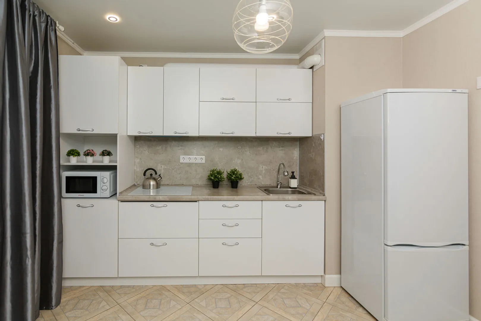 Полноценный кухонный гарнитур с большим холодильником. Кухня наполнена всем необходимым для приготовления и принятия пищи 
