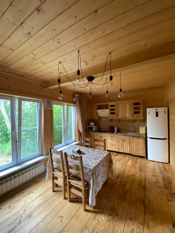 Деревянный дом на берегу реки с беседкой