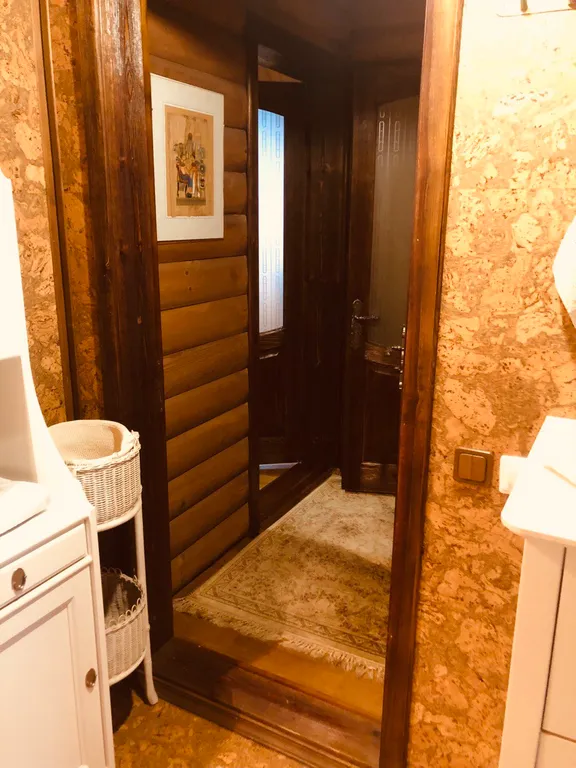 Изба (дом) из экологически чистого бревна под камышовой крышей в лесу