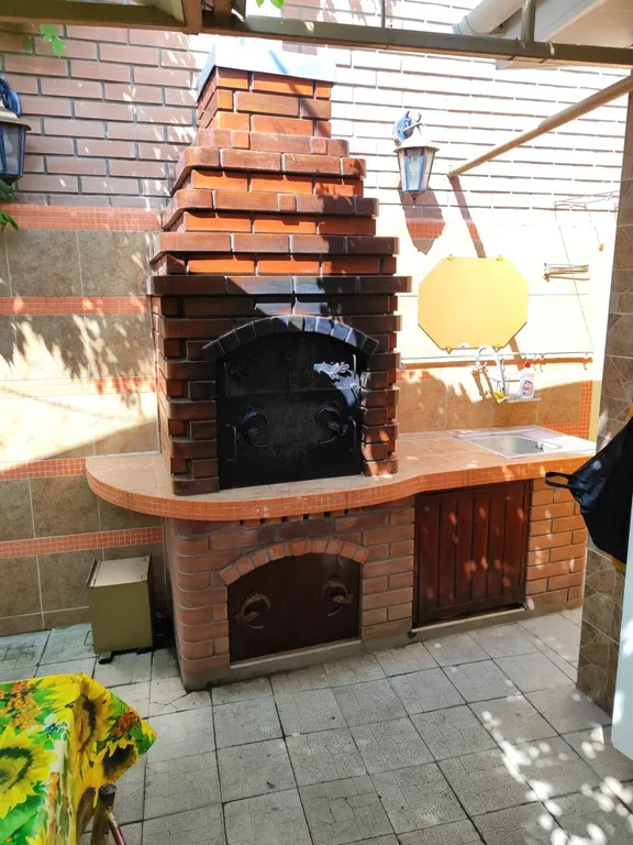 Уютный дом с зелёным двориком и зоной барбекю