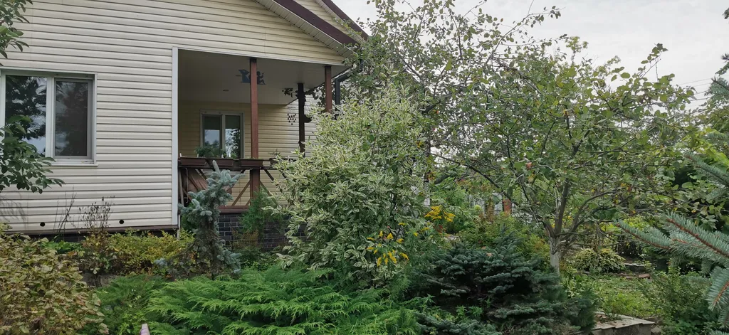 Уютный загородный дом с красивой благоустроенной территорией.