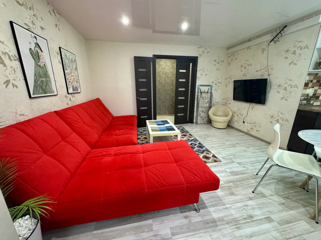 Двухкомнатная студия с красным диваном в центре города