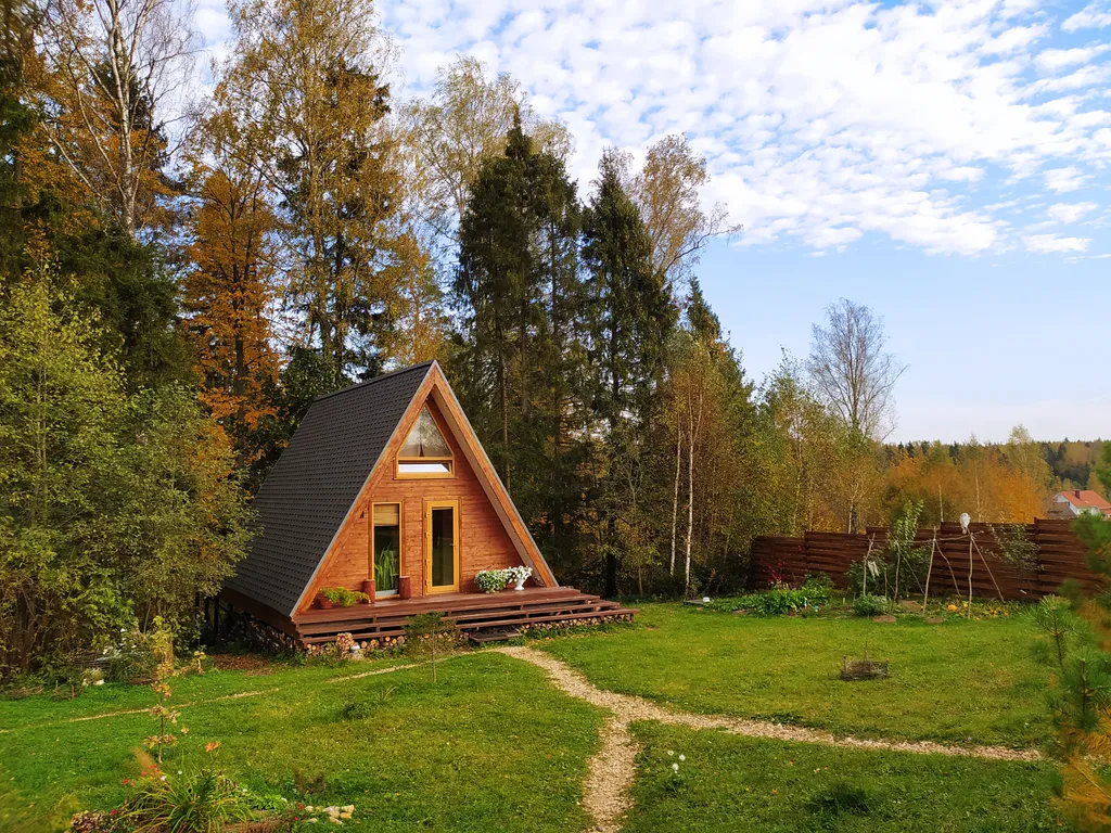Лесной домик a-frame с террасой на холме, среди высоченных елей и берез