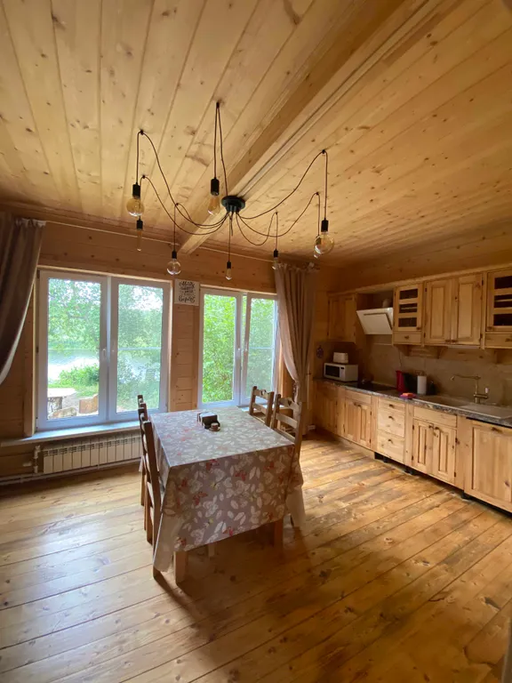 Деревянный дом на берегу реки с беседкой