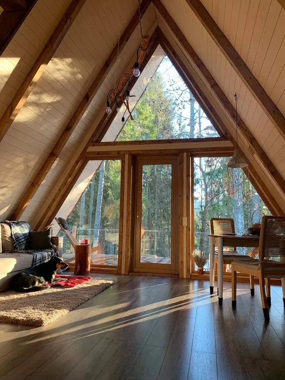 Лесной домик a-frame с террасой на холме, среди высоченных елей и берез