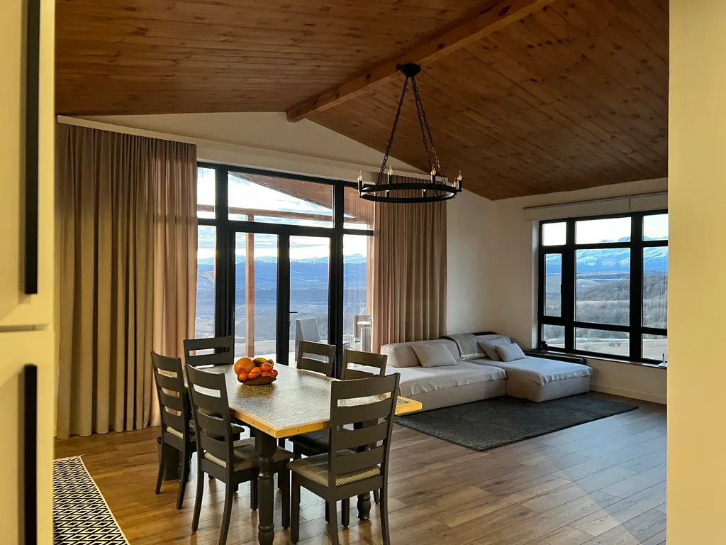 Домик на холме с видом на лес и горы