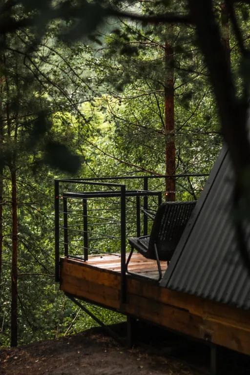 Треугольный домик на склоне горы над ручьём