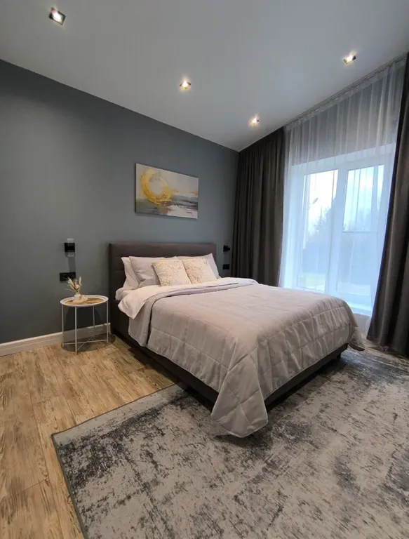 Новый дом в окружении елок с панорамными окнами и баней