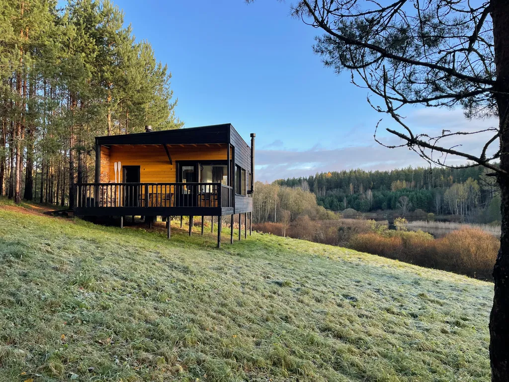 Домик в диком лесу на берегу реки