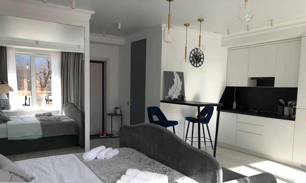 Стильная студия с ванной у панорамного окна и видом на горы