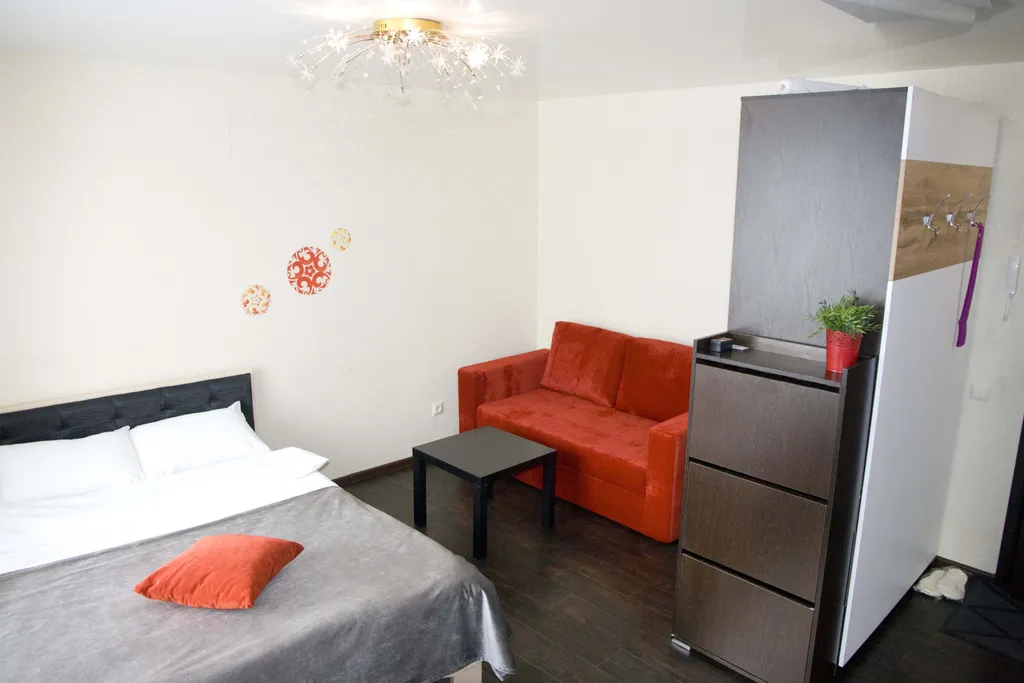 Яркая теплая студия с красным диваном