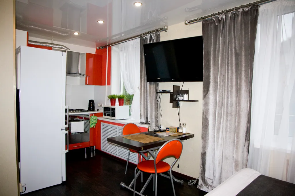 Яркая теплая студия с красным диваном