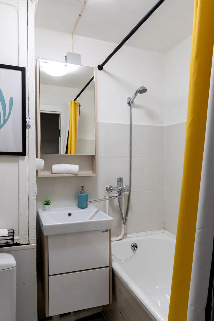 Ванная комната с полотенцами, мылом для рук, гелем для душа и шампунем. Фен в ящике