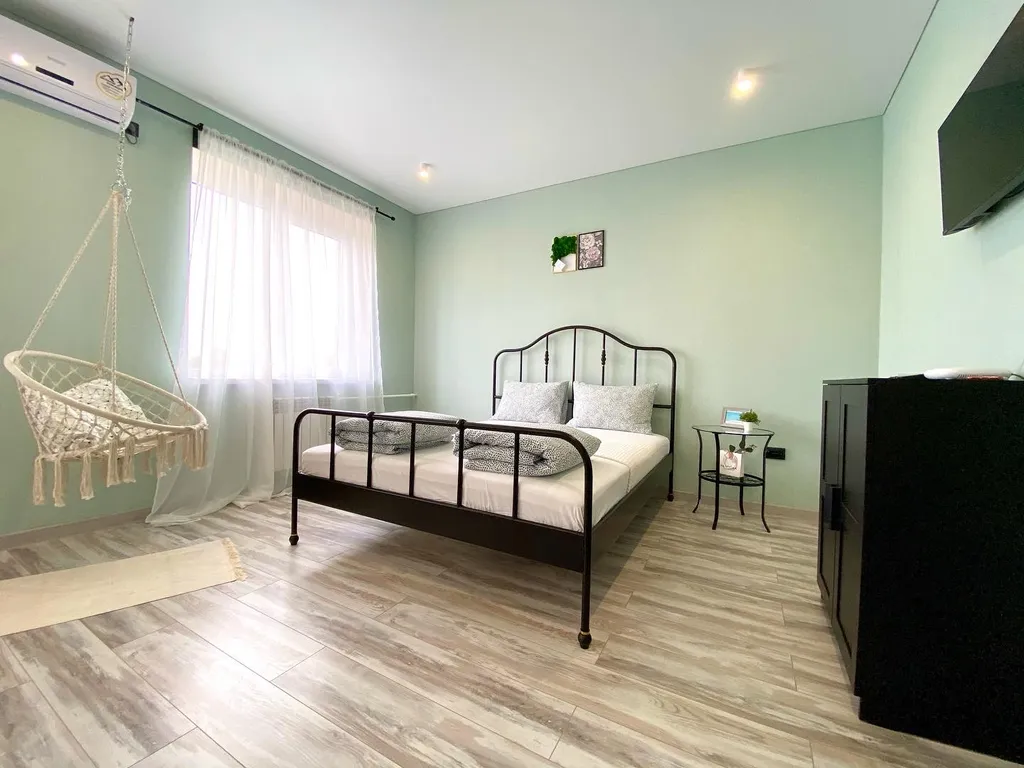 Уютная студия с качелями и видом на тихий зеленый сад