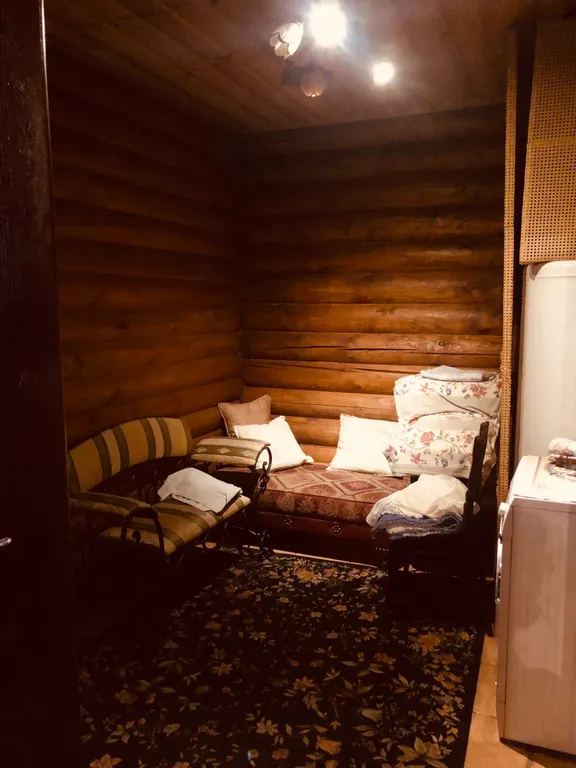 Изба (дом) из экологически чистого бревна под камышовой крышей в лесу