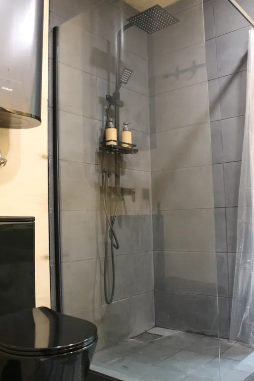 Дом с ванной у панорамных окон и высокой террасой в лесу