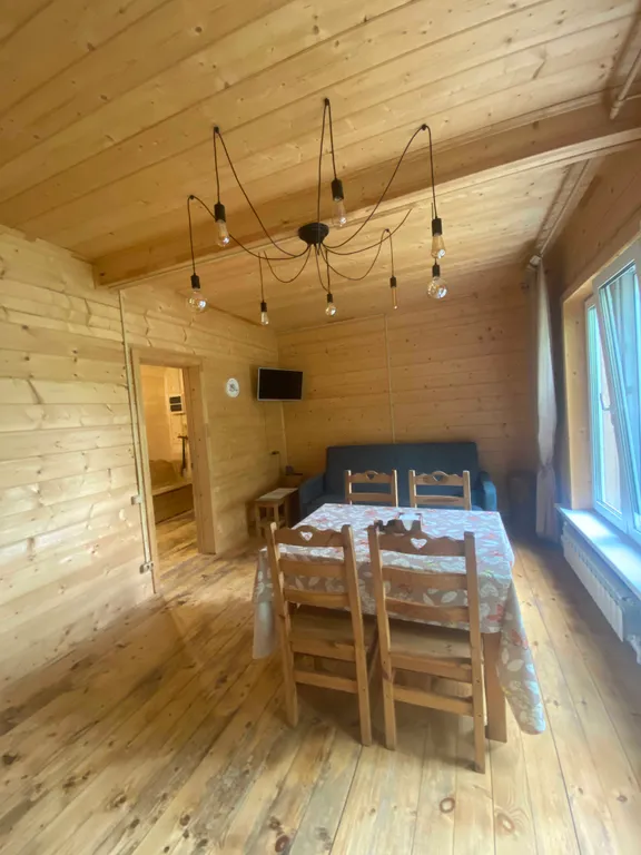 Деревянный дом на берегу реки с беседкой