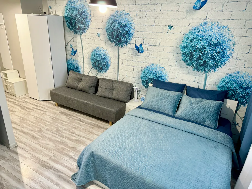 Уютная квартира-студия с большой кроватью и диваном