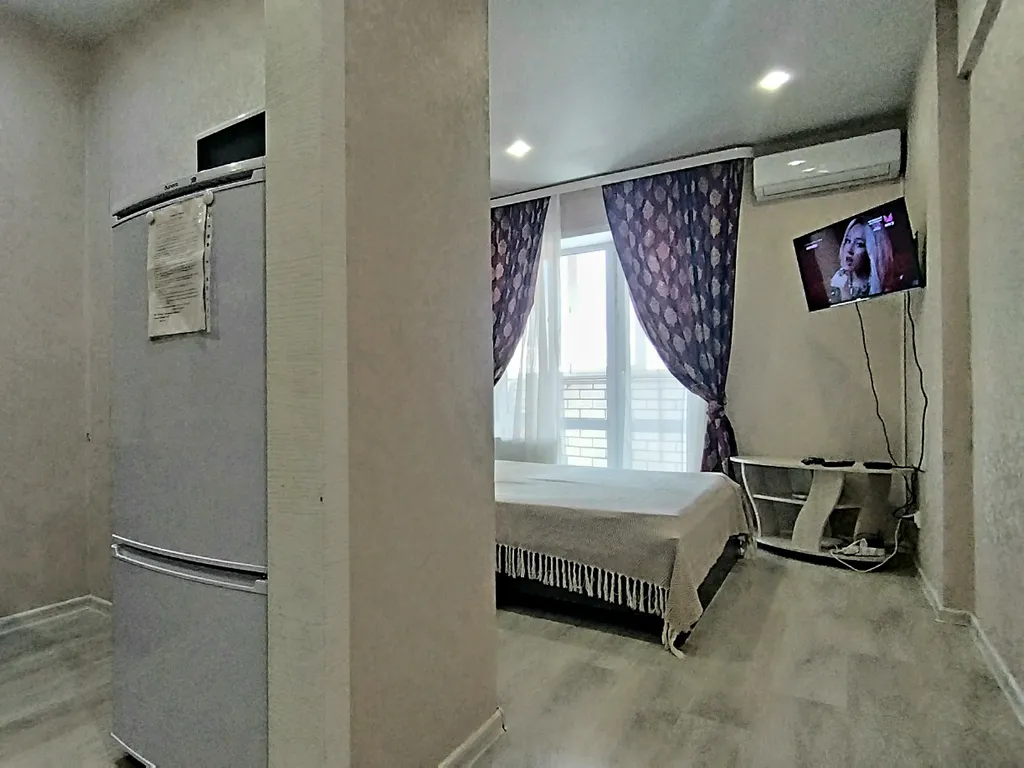 Уютная студия в тёплых тонах с большой угловой ванной для пары