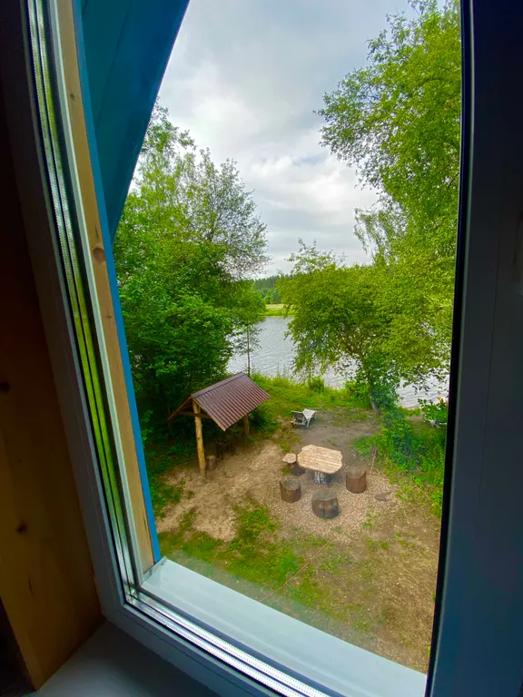 Деревянный дом на берегу реки с беседкой