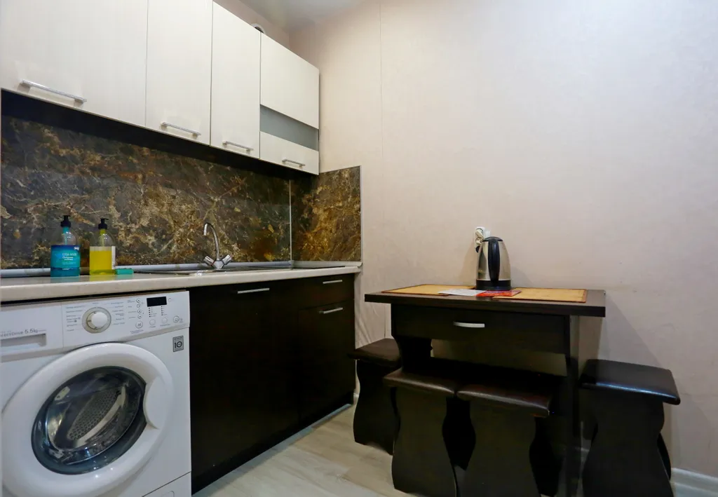 Уютная студия в тёплых тонах с большой угловой ванной для пары