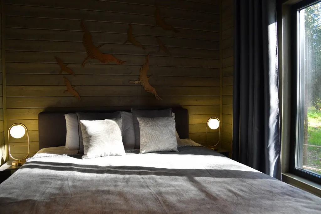 Дом с панорамными окнами в чаще леса у берега реки